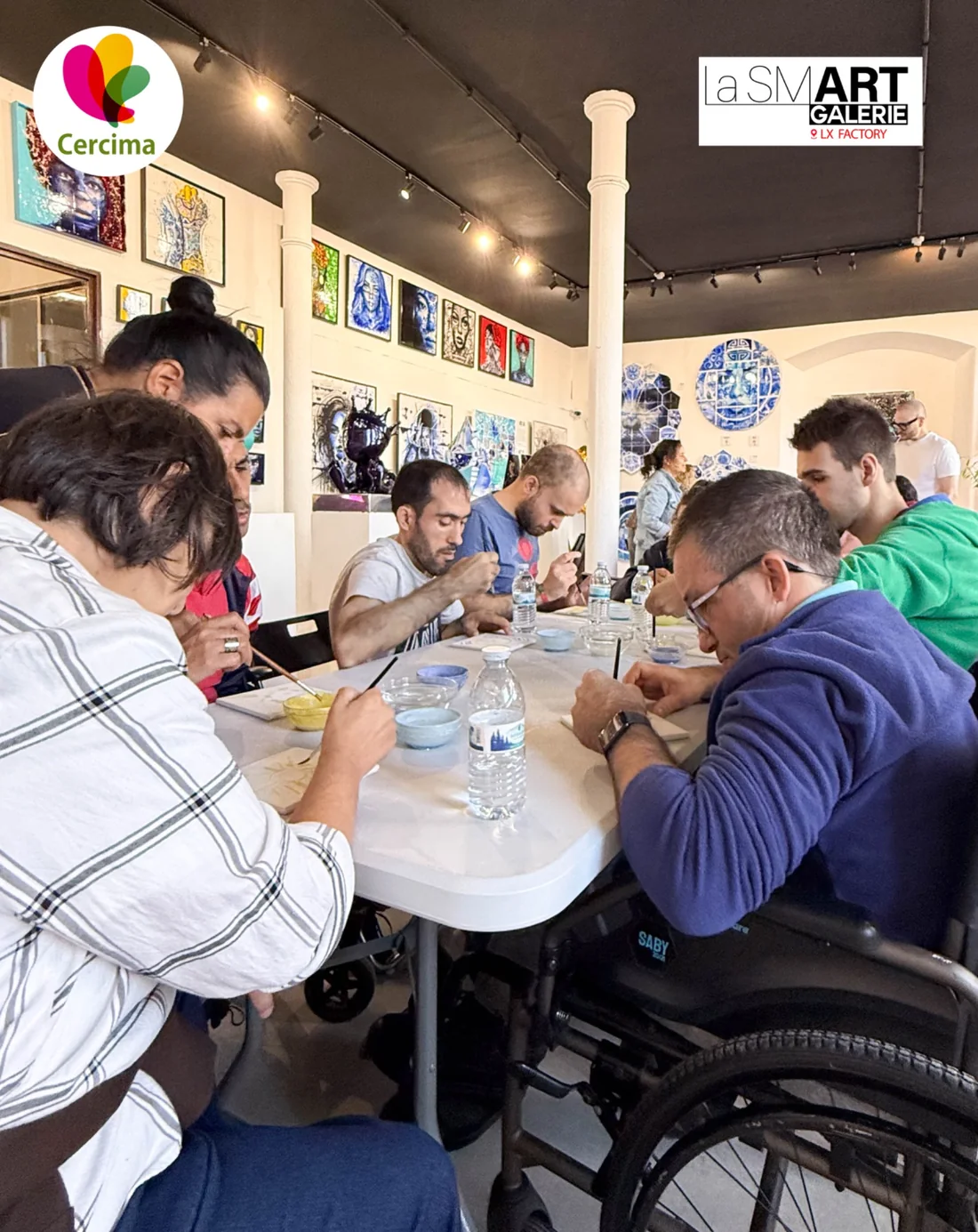 Participantes trabalham com pincéis e tintas sobre azulejos na La Smart Galerie, em Lisboa.