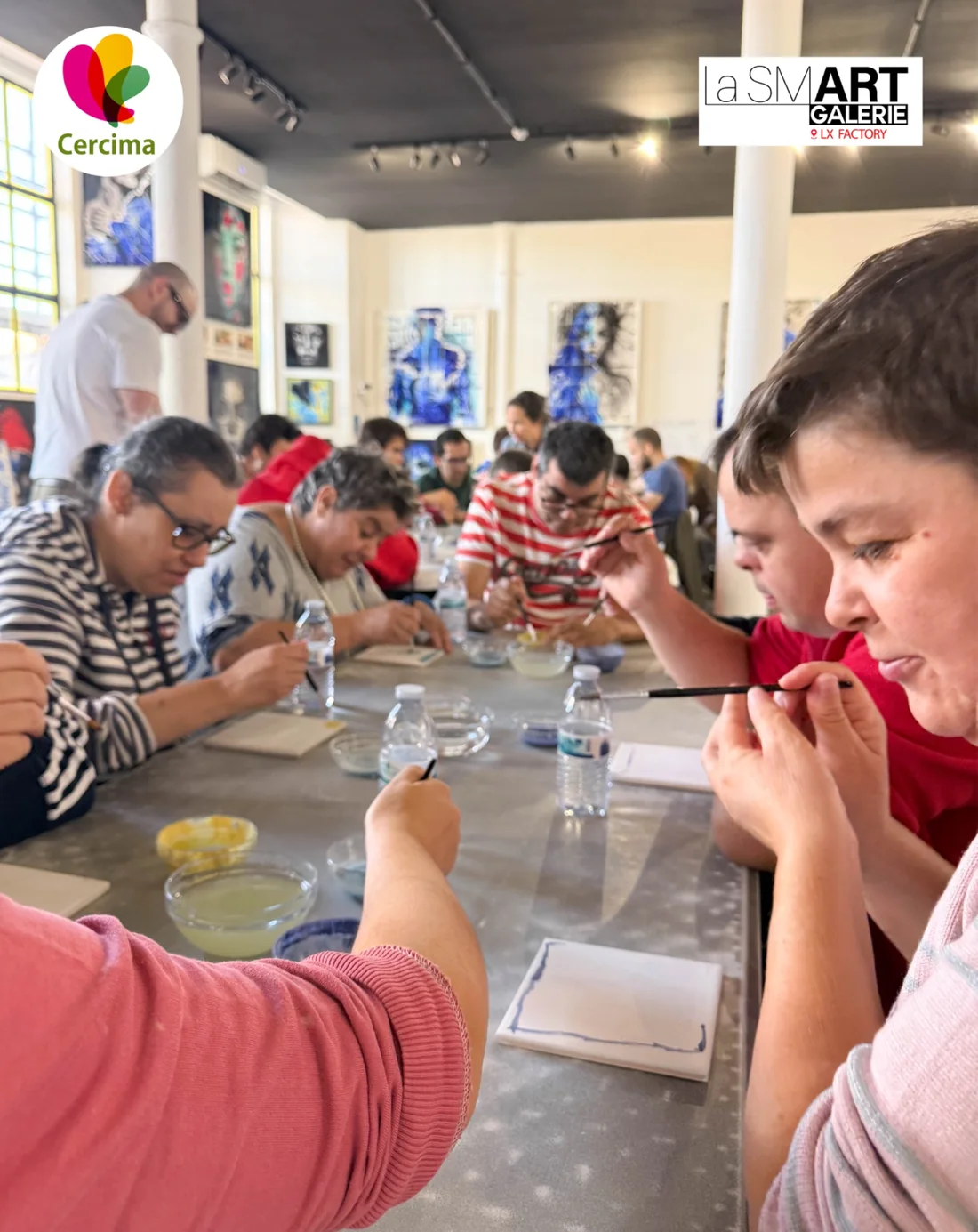 Participantes da CERCIMA pintam azulejos portugueses à mesa numa atividade inclusiva em Lisboa.