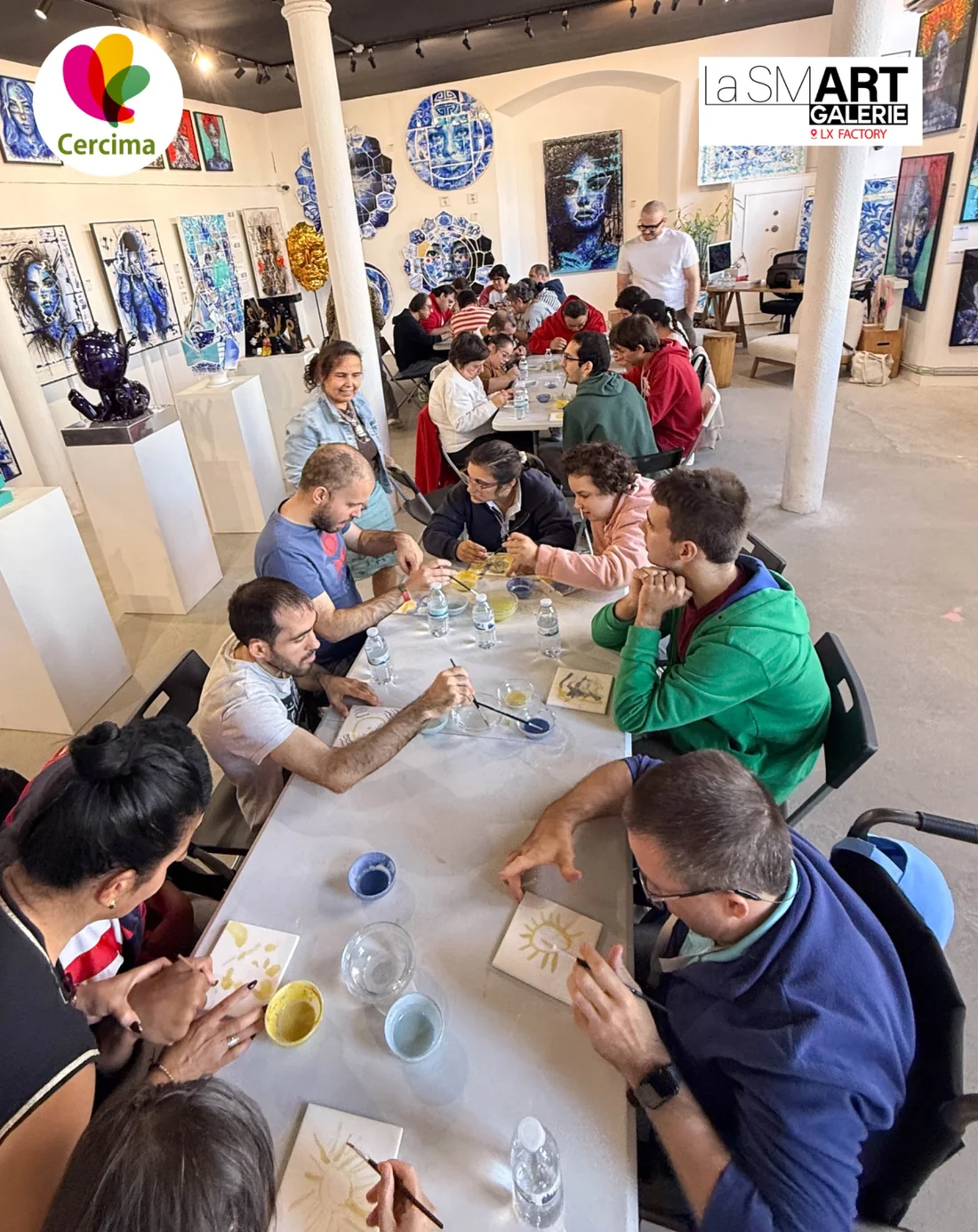 Vista geral do workshop de azulejos da CERCIMA na La Smart Galerie, com participantes em torno das mesas.